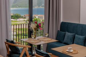 a room with a balcony with a table and chairs at Hotel AQUILO in Petrovac na Moru