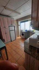 une cuisine avec des placards roses et du carrelage dans l'établissement MiaLife, à Alicante