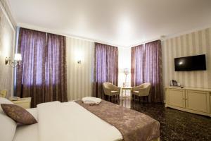 a hotel room with a bed and a table and a television at Chapaev in Voronezh