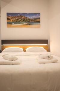 a bedroom with two beds with towels on them at Emily Apartments 2 in Chrysoupolis