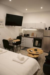 a kitchen with two tables and two chairs and a kitchen with a kitchen at Emily Apartments 2 in Chrysoupolis