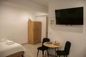 a room with a bed and a small table with chairs at Emily Apartments 2 in Chrysoupolis