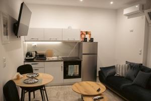 a living room with a couch and a table and a kitchen at Emily Apartments 2 in Chrysoupolis