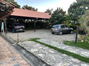 two cars parked in a gravel parking lot at Espléndida casa de campo in Tocancipá