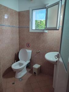 a bathroom with a toilet and a sink and a window at Villa Janilla in Dhërmi +50 photos