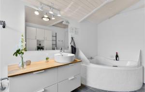 a white bathroom with a sink and a tub at Five-Bedroom Holiday Home In Blokhus in Blokhus