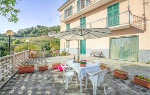 Un patio con una mesa y sillas y una sombrilla. en Pet Friendly Apartment, en Bracco