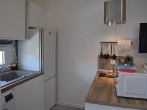 a kitchen with white cabinets and a wooden counter top at Studio ★★★, Climatisé, Wifi, Proche Thermes et Commerces - FR-1-503-140 in Balaruc-les-Bains +4 photos