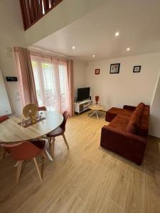a living room with a couch and a table at Petite maison cosy en bord de Marne 2 lits en mezzanine in Maisons-Alfort