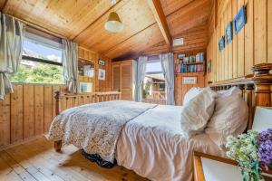 une chambre avec un lit dans une pièce aux murs en bois dans l'établissement Scandinavian Style Lodge in Rock, à Wadebridge