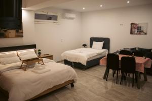 a room with two beds and a table and chairs at Emily Apartments 3 in Chrysoupolis +53 photos
