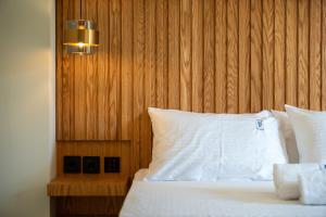 a bed with white sheets and a wooden head board at HP Family Suites in Neos Marmaras +48 photos