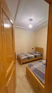 a room with two beds and an open door at Appartement saidia in Saidia 