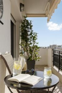 ein schwarzer Tisch mit einem Buch und einer Brille und einem Buch in der Unterkunft 53 Central Luxury Apartment Kalamaria Thessaloniki in Thessaloniki