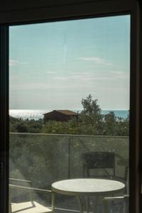 a window with a table and a view of the ocean at HP Family Suites in Neos Marmaras