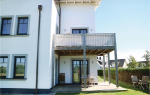 a white house with a deck and a patio at Amazing Apartment In Börgerende in Börgerende-Rethwisch