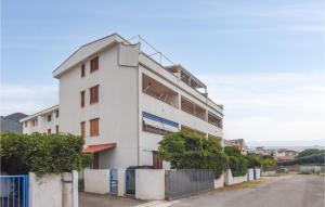 a white building with a fence next to a street at Nice Apartment In Nocera Terinese in Nocera Terinese +7 photos