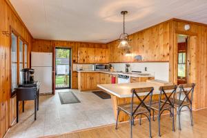 a kitchen with wooden walls and a table and chairs at Hale Rustic Retreat on Long Lake Near Boat Launch! in Hale