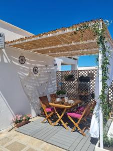 un patio con mesa y sillas bajo una pérgola en La terrazza di Zoe - Castromediano ( Lecce), en Cavallino di Lecce