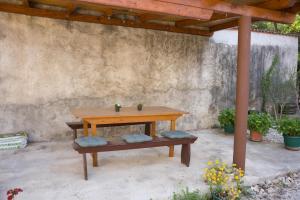 a wooden table and bench in a patio at Apartman Vito in Drniš