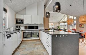 a kitchen with white cabinets and a dining room at Gorgeous Home In Glesborg With Sauna in Glesborg