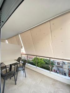 Valbona Apartment في سارنده: غرفة بها طاولة وكراسي ونافذة كبيرة