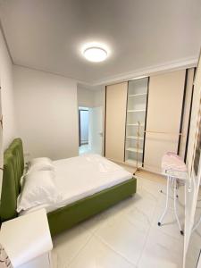 Valbona Apartment في سارنده: غرفة نوم بها سرير وكرسي