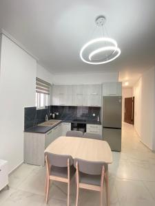 Valbona Apartment في سارنده: مطبخ مع طاولة وكرسيين وثلاجة