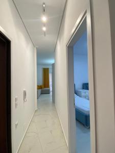 Valbona Apartment في سارنده: ممر يؤدي إلى غرفة مع غرفة نوم +صورة واحدة