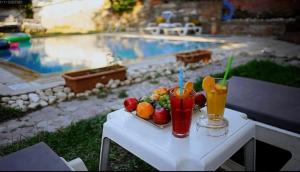a tray of fruit and drinks on a table next to a pool at Kybele Taş Konak in Kusadası