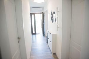 a hallway with white walls and a wooden floor at Apartman Vito in Drniš