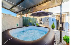 a hot tub on a patio with an umbrella at 1 Bedroom Lovely Home In Barat in Barat