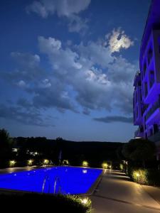 a large blue swimming pool in a city at night at Azur Properties ap19 in Shkorpilovtsi