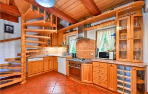 una cucina con armadi in legno e una scala di Nice Home In Varazdin With Sauna a Gornja Voća