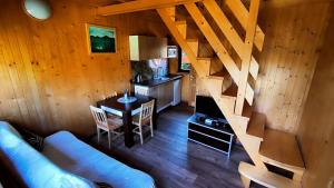 a living room with a couch and a table and a kitchen at Domki Tina in Międzybrodzie Żywieckie