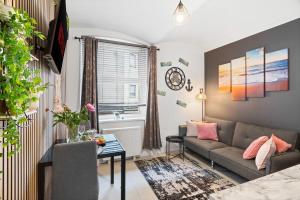 Stylish 1-Bedroom Apartment near Beach - Brighton في برايتون أند هوف: غرفة معيشة بها أريكة وطاولة