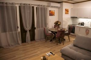 a living room with a table and a kitchen at Emily Apartment 5 in Chrysoupolis