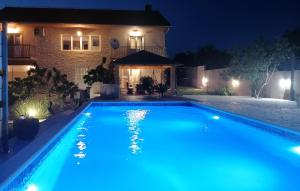 une piscine devant une maison la nuit dans l'établissement 4 Bedroom Gorgeous Home In Lisicic, à Lisičići 40 autres photos