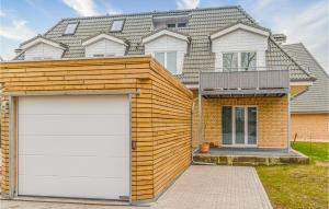 a wooden house with a garage in front of it at Lovely Apartment In Timmendorfer-Strand in Timmendorfer Strand
