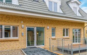 a yellow brick house with a sliding glass door at Lovely Apartment In Timmendorfer-Strand in Timmendorfer Strand