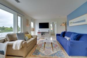 a living room with a couch and a tv at Cozy Narragansett Cottage with Dock and Outdoor Shower in Narragansett