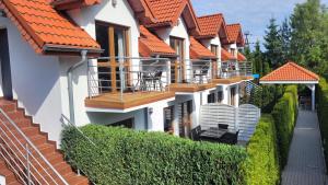 a row of houses with orange roofs at Villa Żeglarzy-Apartamenty 3pokojowe in Rusinowo