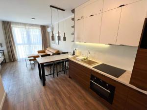 a kitchen with a sink and a table with chairs at Belzacka Studio in Piotrków Trybunalski