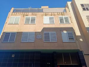 a tall building with blue shuttered windows on it at Lindo y Discreto apartamento playa in Moncófar