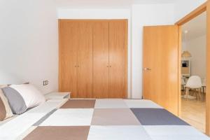 a bedroom with a bed and a wooden door at Lindo y Discreto apartamento playa in Moncófar