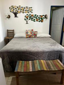 a bedroom with a bed with a bench on it at Pouso Bem Estar in Tiradentes