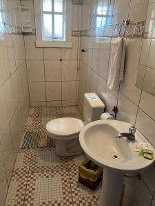 a white bathroom with a toilet and a sink at Pouso Bem Estar in Tiradentes +57 photos
