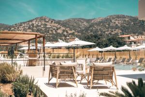 a patio at a resort with chairs and a pool at Sivota Hotel in Sivota