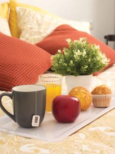 a tray with an apple and juice and muffins on a bed at Casa Koala VT14462 in Pinto