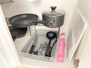 a container with a pan and utensils in a kitchen at Studio Flat near Waterside Theatre in Aylesbury